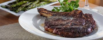 The Capital Grille signature dishes Dry-Aged Porterhouse Steak, Seared Tenderloin with Butter Poached Lobster Tails, Pan-Fried Calamari with Hot Cherry Peppers, Lobster Mac 'N' Cheese.